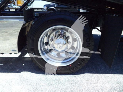Kenworth T280 rollback truck wheel area showing front wheel and chrome hubcap, partial undercarriage, black chassis, and metal frame.