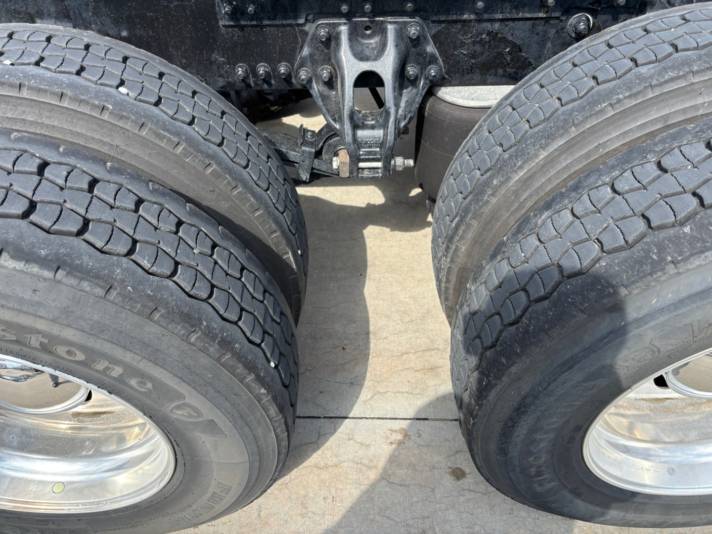 Kenworth T680 rear axle and dual tires view showing tandem axle and fifth wheel area.