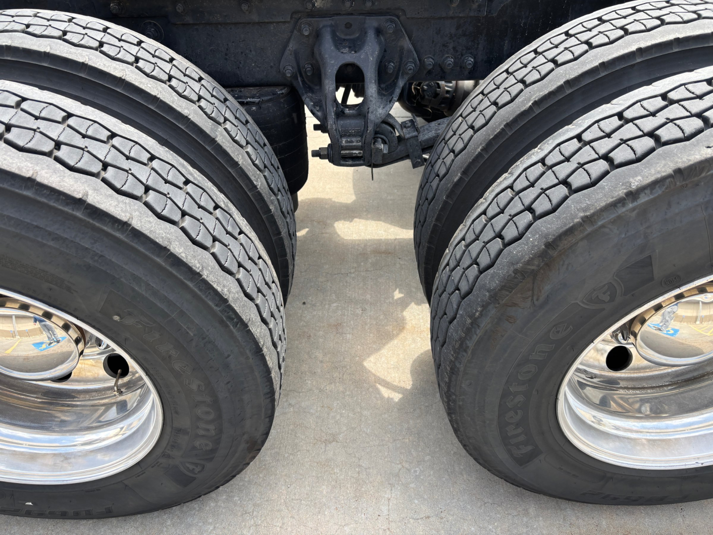 Kenworth T680 rear dual-drive axle area with wheels and suspension components visible; no text legible on image aside from wheel rims.