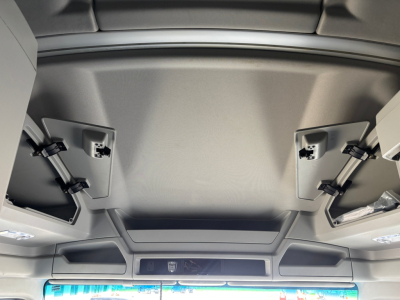 No text visible; interior ceiling area of a Kenworth T680 cab with overhead compartments and sun visors.