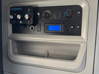 Kenworth T680 dash area showing climate controls, digital radio, and dashboard switches.