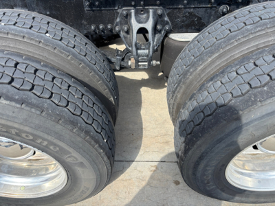 Kenworth T680 rear axle and dual tires view showing tandem axle and fifth wheel area.