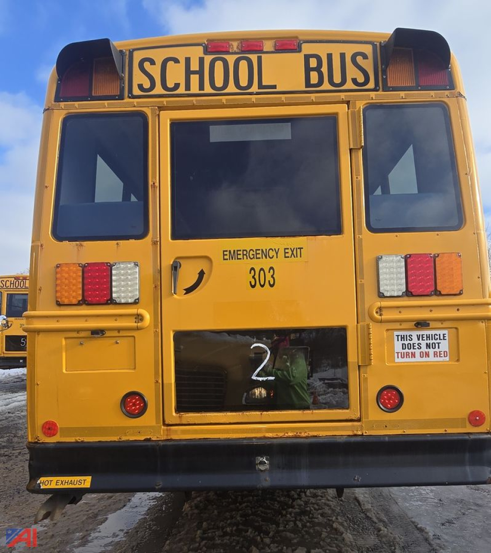 Rear view of a yellow school bus with 'SCHOOL BUS' sign, emergency exit 303, and a large black rear window.
