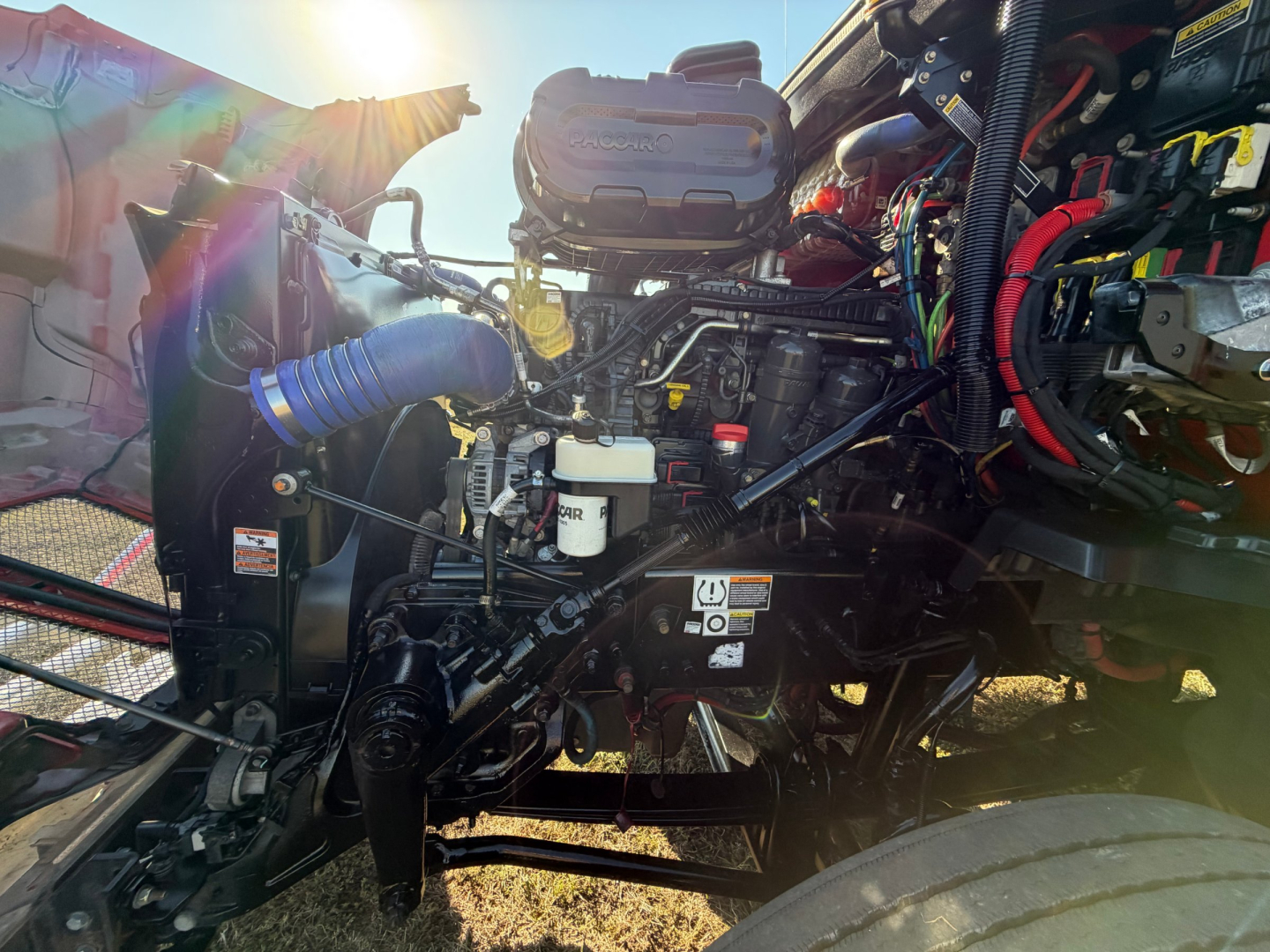 Kenworth T680 engine bay showing diesel engine with hoses, wiring, and components in a sleeper tractor.