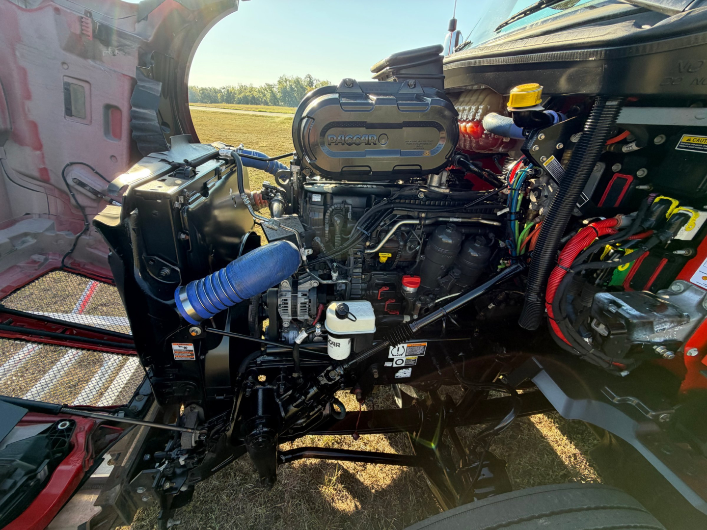 Kenworth T680 truck engine bay showing Cummins turbo diesel engine and surrounding components.