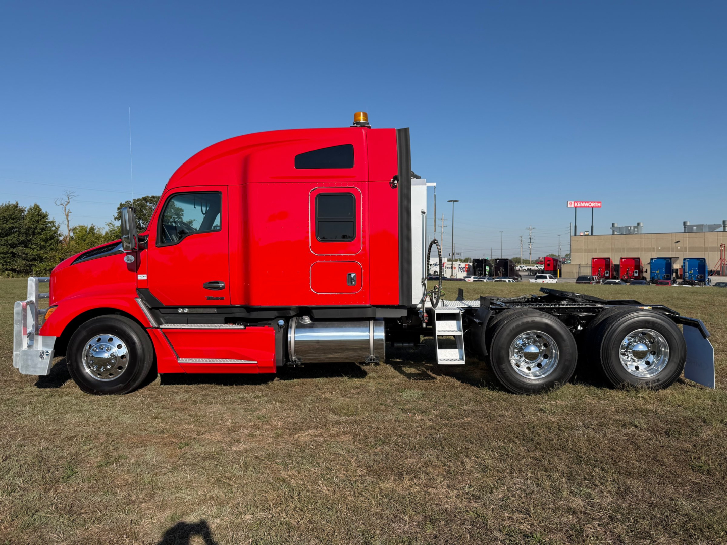 Kenworth T680 tractor in red profile view showing sleeper cab, chrome fuel tanks, and dual rear axles.