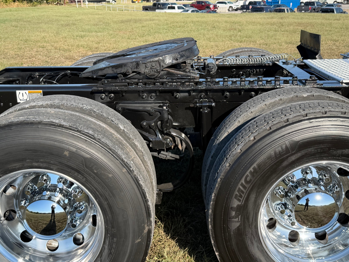 Kenworth T680 trucks chassis with dual rear axles and chrome wheels, visible fifth wheel and cab area, no cab interior visible in this view.