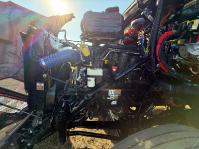 Kenworth T680 engine bay showing diesel engine with hoses, wiring, and components in a sleeper tractor.