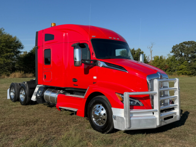 Kenworth T680 semi truck in red, side view showing cab with sleeper, chrome front bumper, dual rear axles, and fuel tanks.