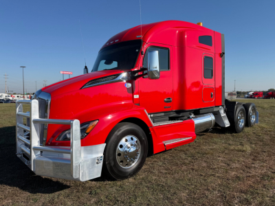 Kenworth T680 truck in red, side view showing cab, air intake, and chrome bumper guard.