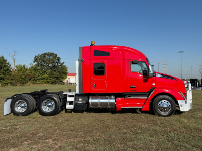 Kenworth T680 conventional sleeper truck in red, side view showing fuel tanks and dual rear axles.