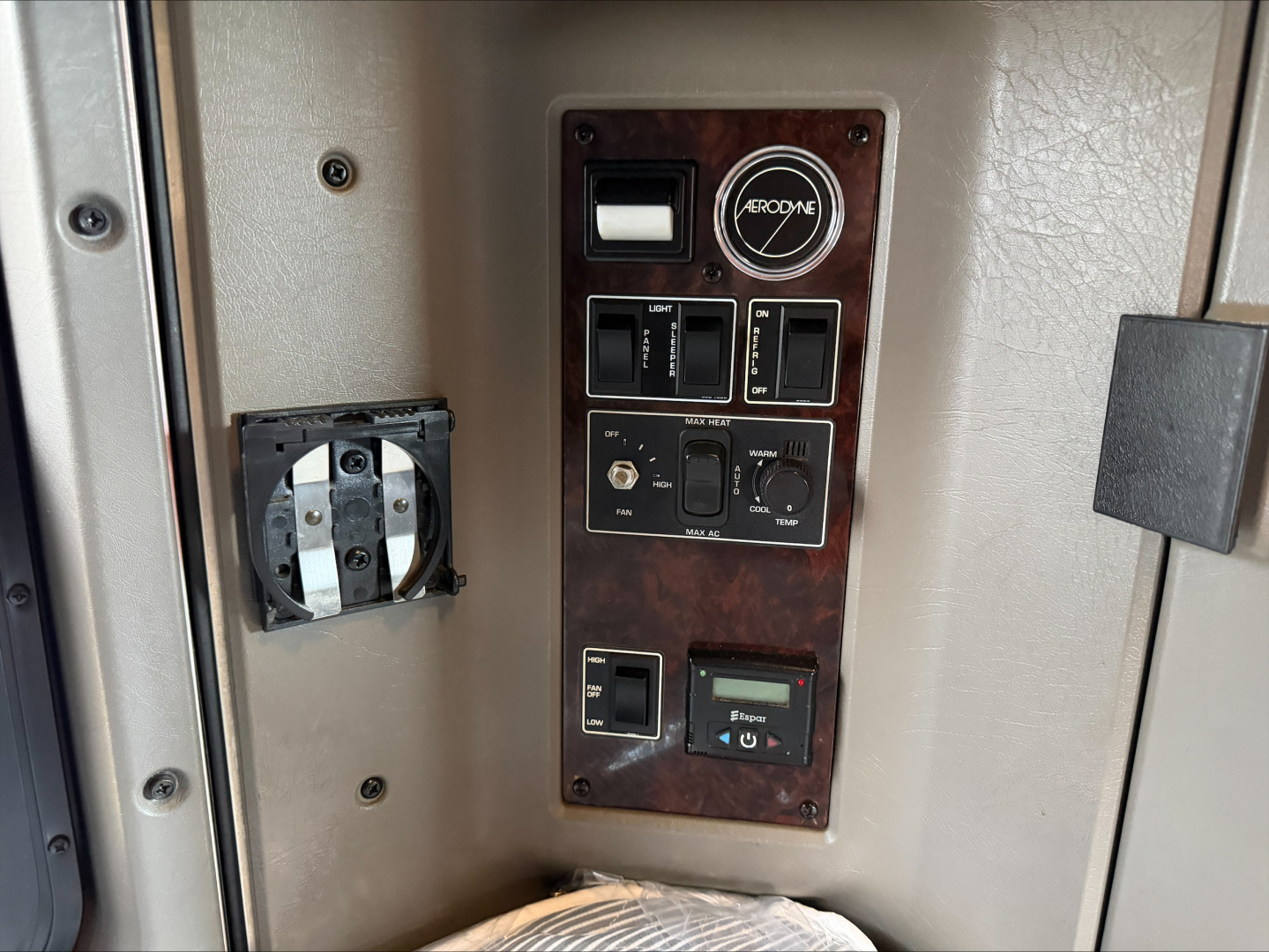 Kenworth W900L dashboard control panel and power outlet panel in cab showing switches and gauges.
