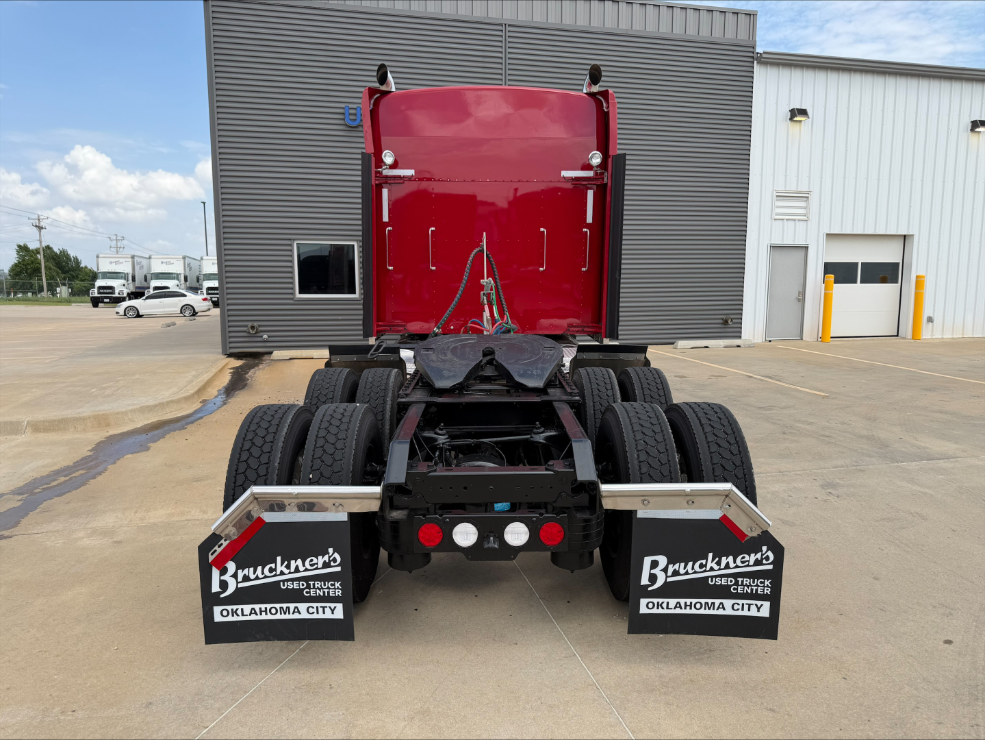 Kenworth W900L tractor rear view showing dual rear axles and mudflaps with Bruckner's Oklahoma City branding.