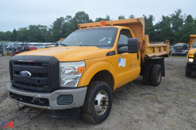 Ford F-350 Super Duty dump truck in yellow with cargo bed, front view showing grille and bumper