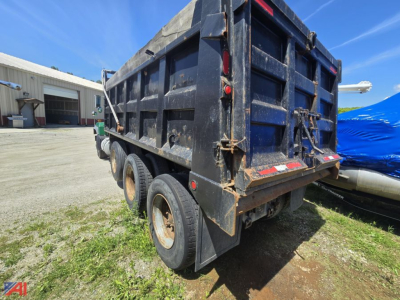 Dump truck rear view showing Mack RD688S dump body, reinforced tailgate, three axle tires, and hydraulic hitch points.