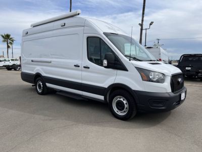 Ford Transit van in side angle view showing cargo space with roof rack and extended van body.
