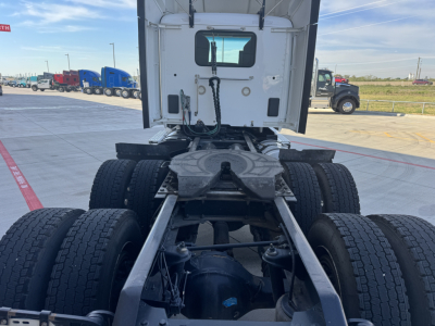 Kenworth T680 tractor view from rear showing chassis and tandem axles, fifth wheel area, and rear cab window.