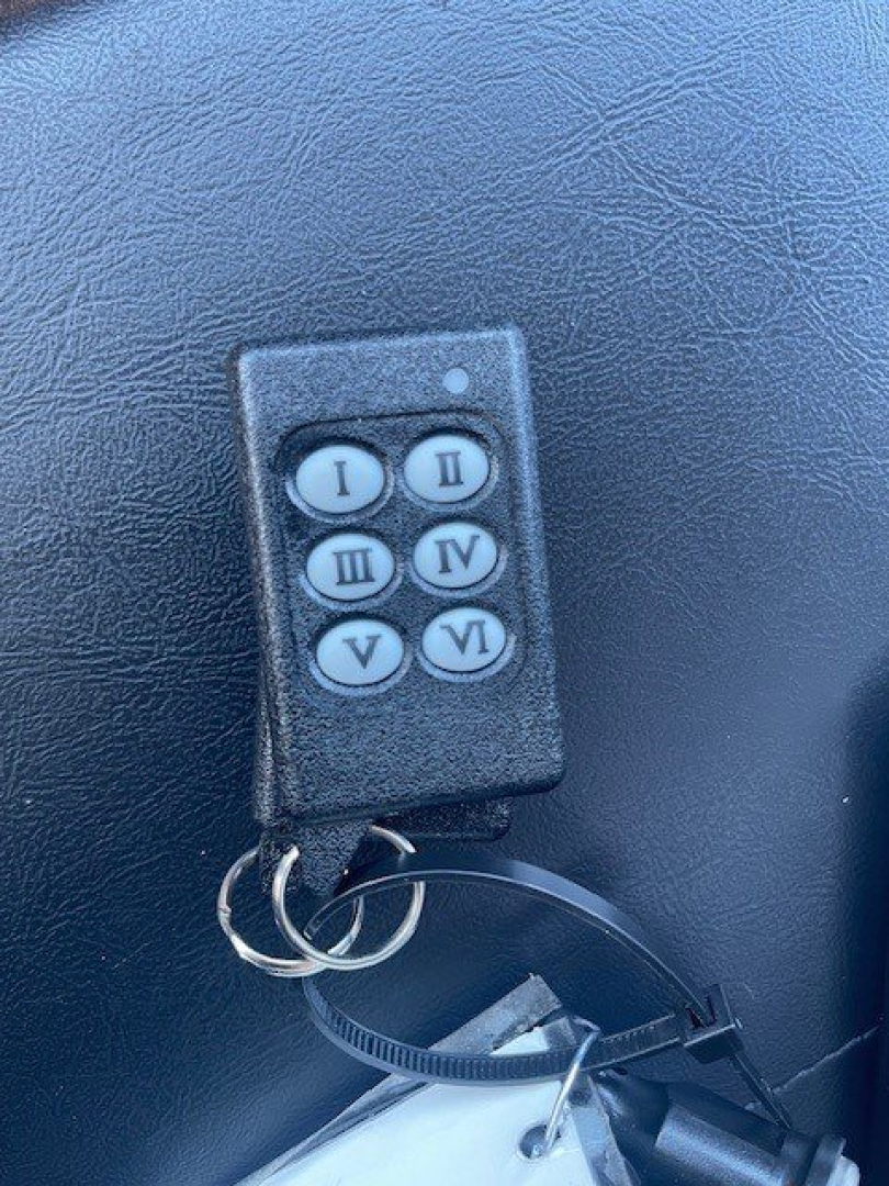 Truck interior image showing a six-button key fob labeled I II III IV V VI attached with a wire to a panel surface
