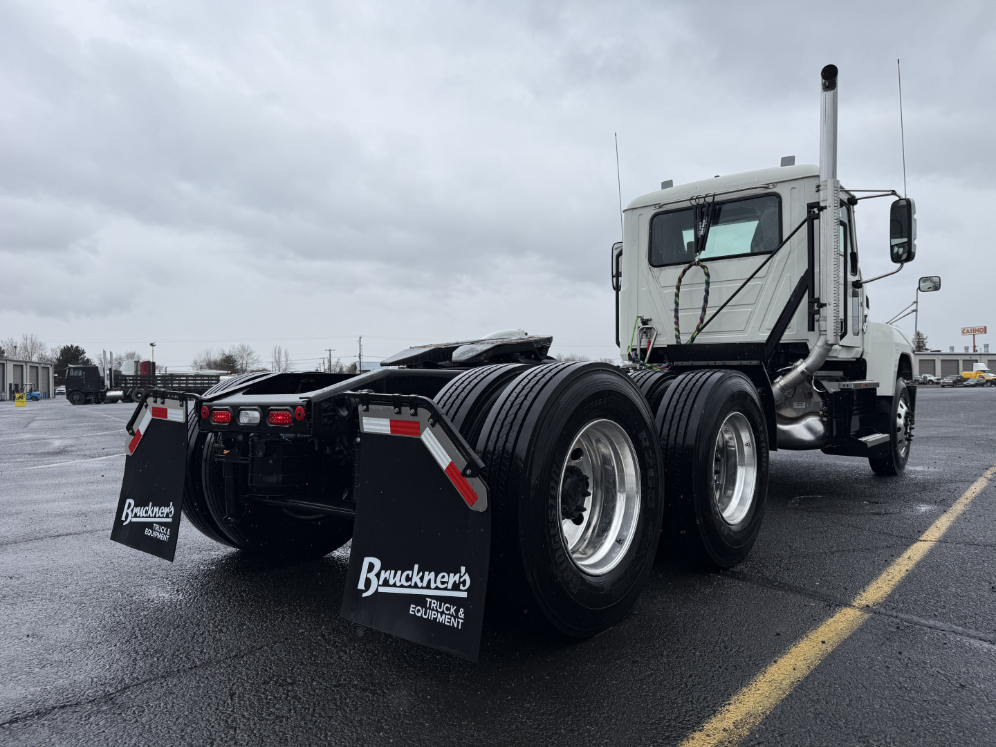 Mack PI64T truck rear view showing dual rear axles and mud flaps with Bracken's Truck & Equipment branding