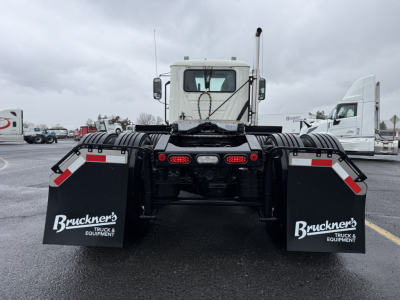 Truck rear view showing mud flaps and fifth-wheel hitch on a new Mack PI64T daycab.
