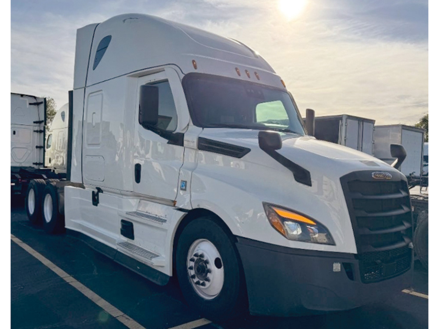 Truck cab exterior shown for a 2022 Freightliner Cascadia126 sleeper tractor with white paint, black grille, and side mirrors.