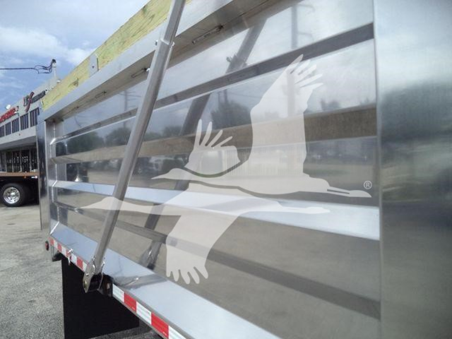 Truck dump trailer side panel with a large white eagle graphic and horizontal metal slats.