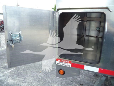 Truck bed with aluminum 14 ft dump body showing open rear door and warning label; stock number ADFAB14FTALUM1 visible, category Dump, new truck.