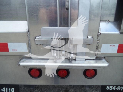 Back of a dump truck showing taillights and bumper with latch and chain, visible text includes stock number ADFAB14FTALUM1 and 954-?? area; aluminum surface reflections.