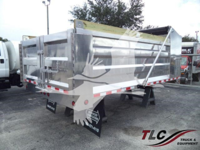 Dump trailer side and rear showing aluminum 14 ft bed with hinged tailgate, reflective tape, and black mud flaps with white text.