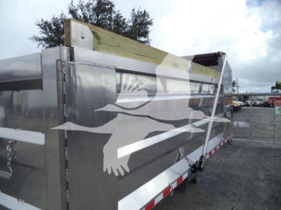 Dump truck bed side panel of 2025 Advanced Fabricators 14 ft dump truck showing metallic aluminum cargo bed with reflective white bird graphic and red/white safety reflective tape along bottom edge.