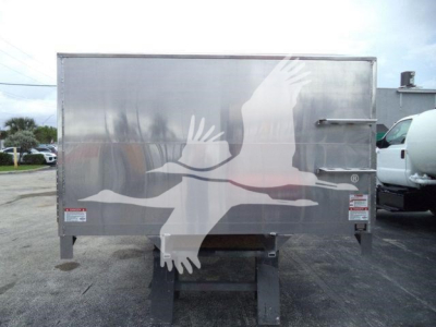 Dump trailer back view showing stocky steel frame and reflective aluminum panels with a large graphic of birds in flight.