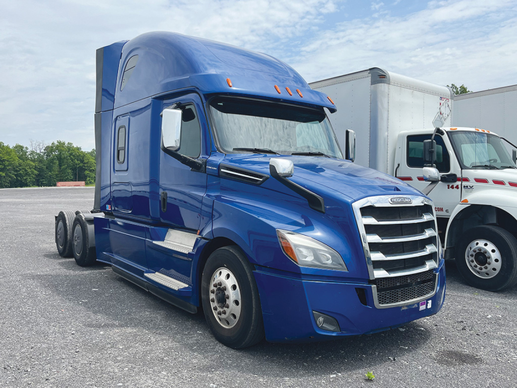 Freightliner Cascadia126 sleeper cab tractor in blue with chrome grille and dual rear axles, side mirrors, and daytime running lights.