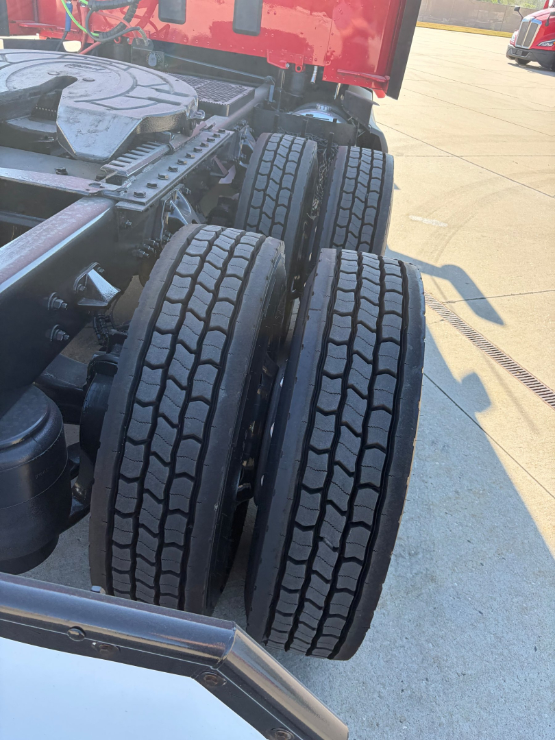 Kenworth T680 truck chassis showing dual rear axles with tires and suspension components.