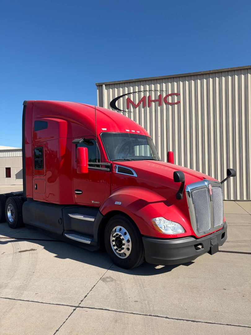 Kenworth T680 truck in red exterior parked outside a building.
