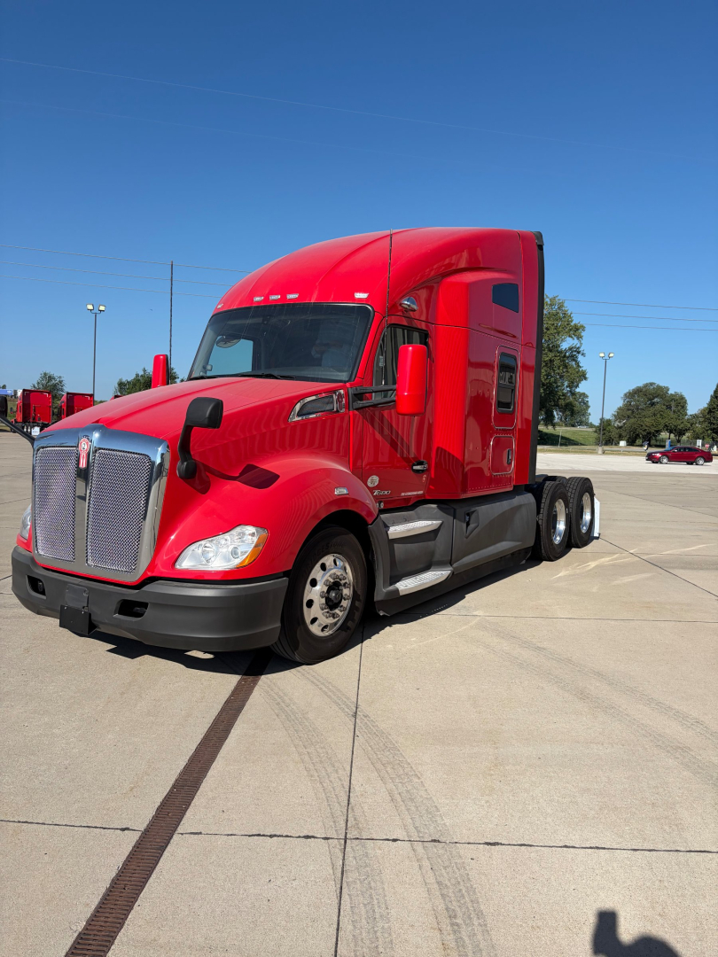 Kenworth T680 conventional sleeper truck in red, front three-quarter view, showing cabin and front grille.