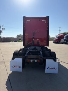 Rear view of a red Kenworth T680 truck tractor showing fifth wheel, rear lights, and mud flaps with MHC logos.