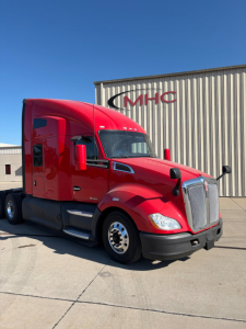 Kenworth T680 truck in red exterior parked outside a building.