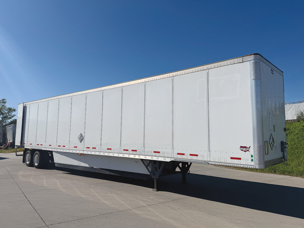 Wabash DuraPlate dry van trailer showing side profile, silver aluminum exterior, logo placards, and rear underride with support legs extended.