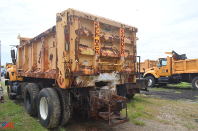 Dump truck rear view showing rusted dump body with back doors and hydraulic mechanism, International WorkStar 7400 in field