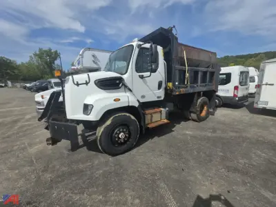 Dump truck with dumping bed, white Freightliner 108SD, front view showing cab and side of bed, indicating VIN 1FVAG5BS9DHFA4388 in a used truck lot.