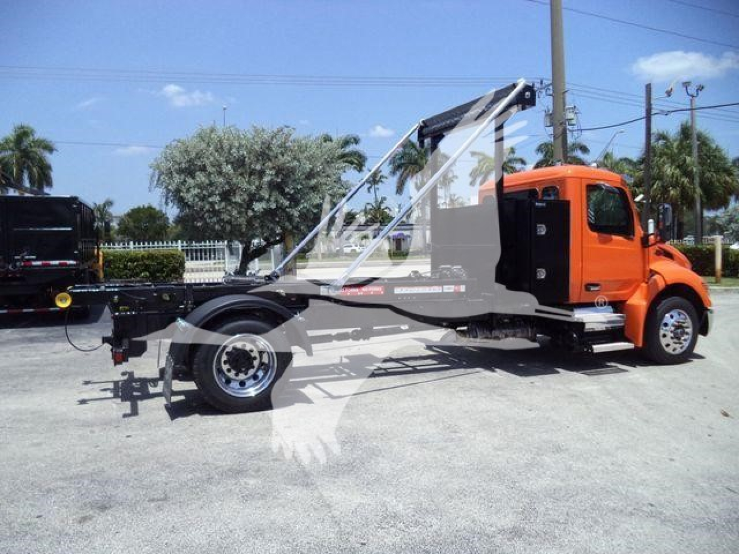 Peterbilt 536 tow truck chassis in orange showing side profile and boom arm with hydraulic winch.