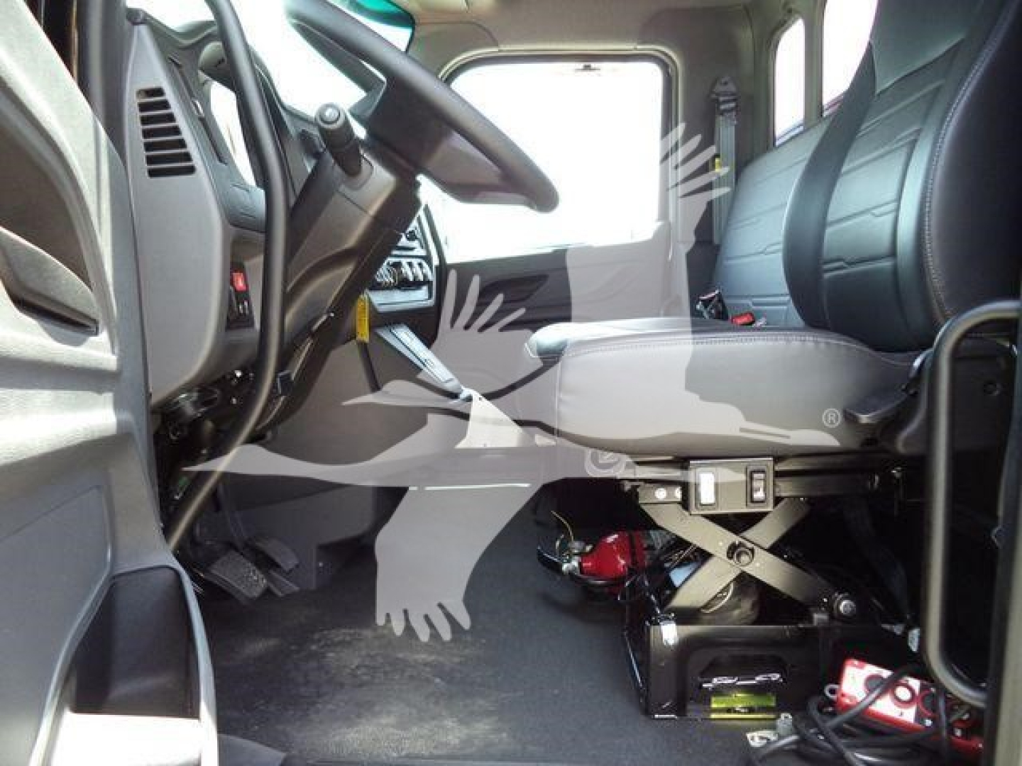Truck cab interior showing driver's seat and steering wheel of a new Peterbilt 536 with visible floor area and control panel.