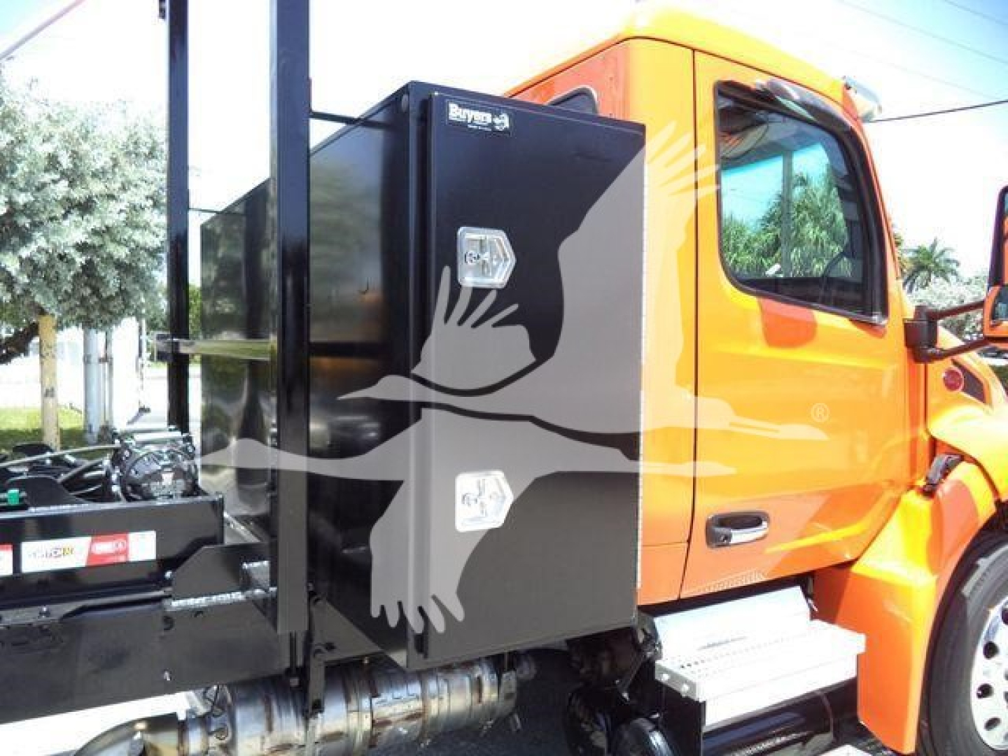 Peterbilt 536 cab with attached black toolbox and orange cab in-service. Side view shows door, step, and hydraulic components.