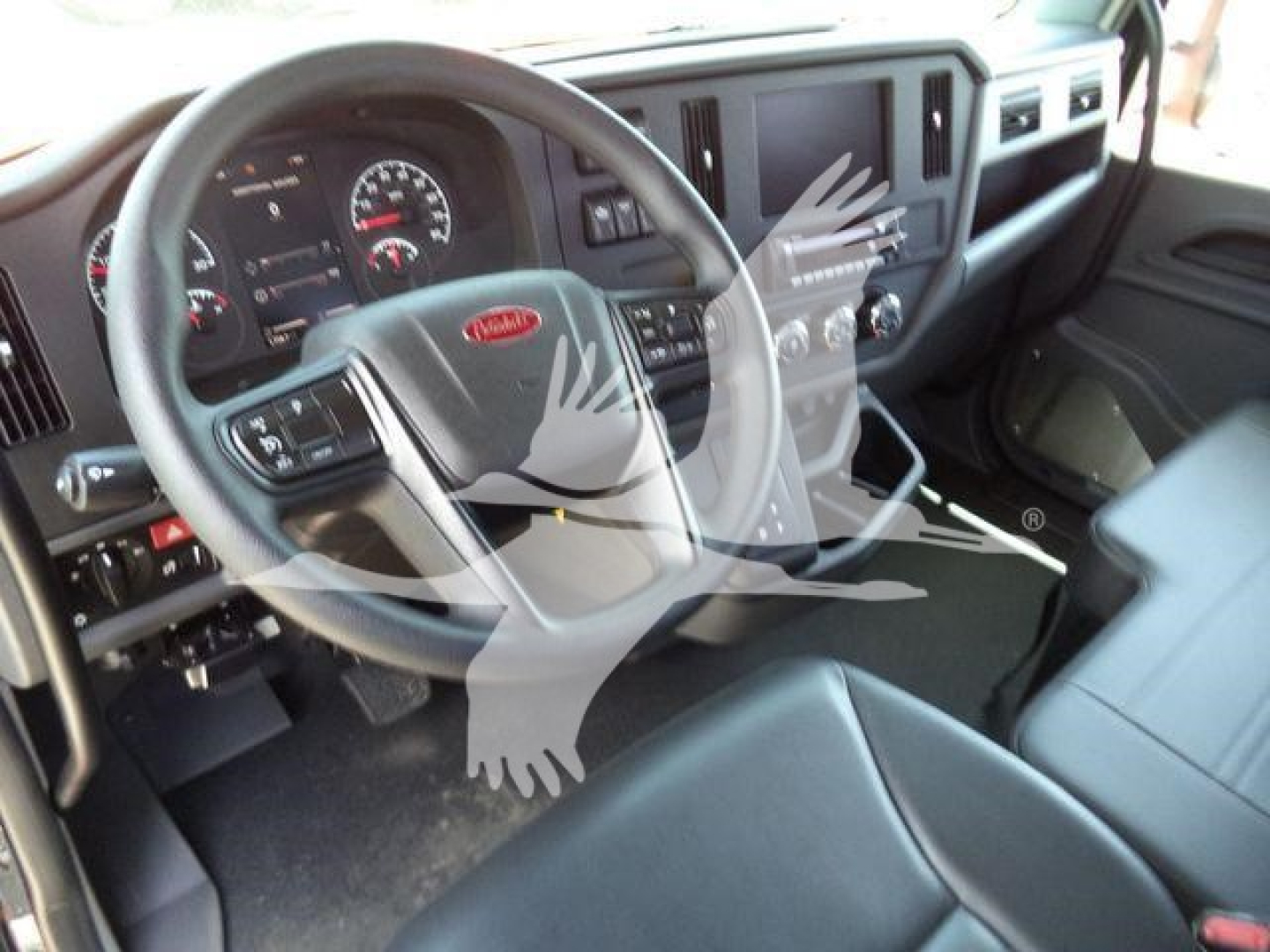 Peterbilt 536 interior showing steering wheel with Peterbilt logo and dashboard, center touchscreen, and driver's seat.