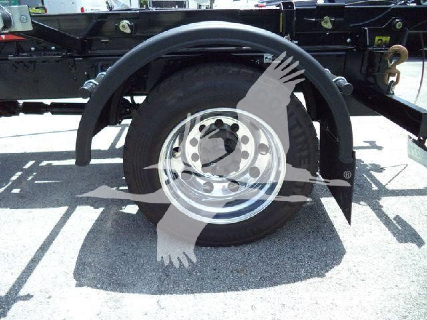 Rear wheel and fender of a Peterbilt truck chassis showing a single rear wheel with chrome rim and black mudguard underframe components.