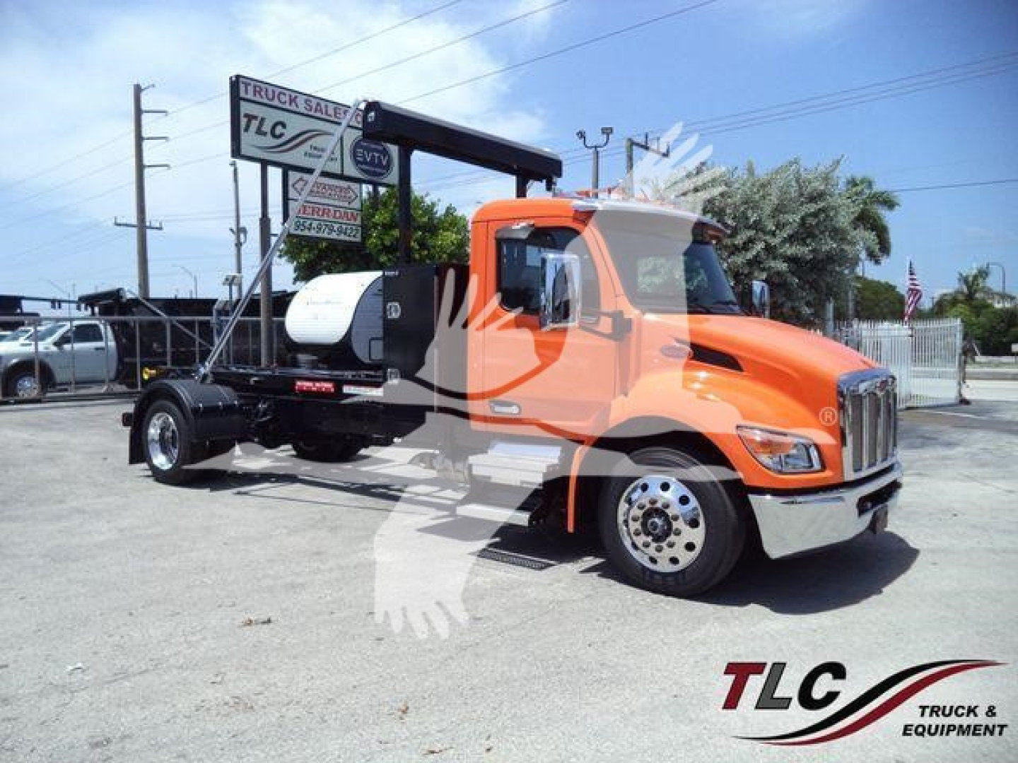 Peterbilt 536 truck on lot with orange cab and black frame, side view showing fuel tank and side mirror.