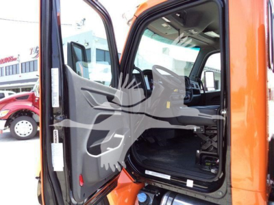 Peterbilt 536 cab interior view through open driver door showing orange exterior and black interior dash