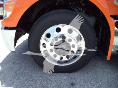 Front wheel of orange Peterbilt 536 truck showing polished steel hub and black tire.