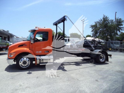 Peterbilt 536 truck in orange cab, side view showing wheel base and chassis for a rollback tow configuration