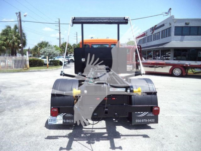 Rear view of a new Peterbilt 536 truck on lot showing hitch, taillights, and chassis components.